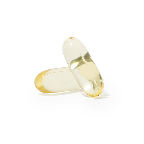 Two translucent vegan softgel capsules with golden liquid inside