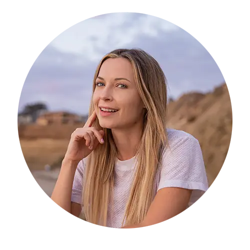 a smiling woman wearing a white top feeling good about her radiant skin